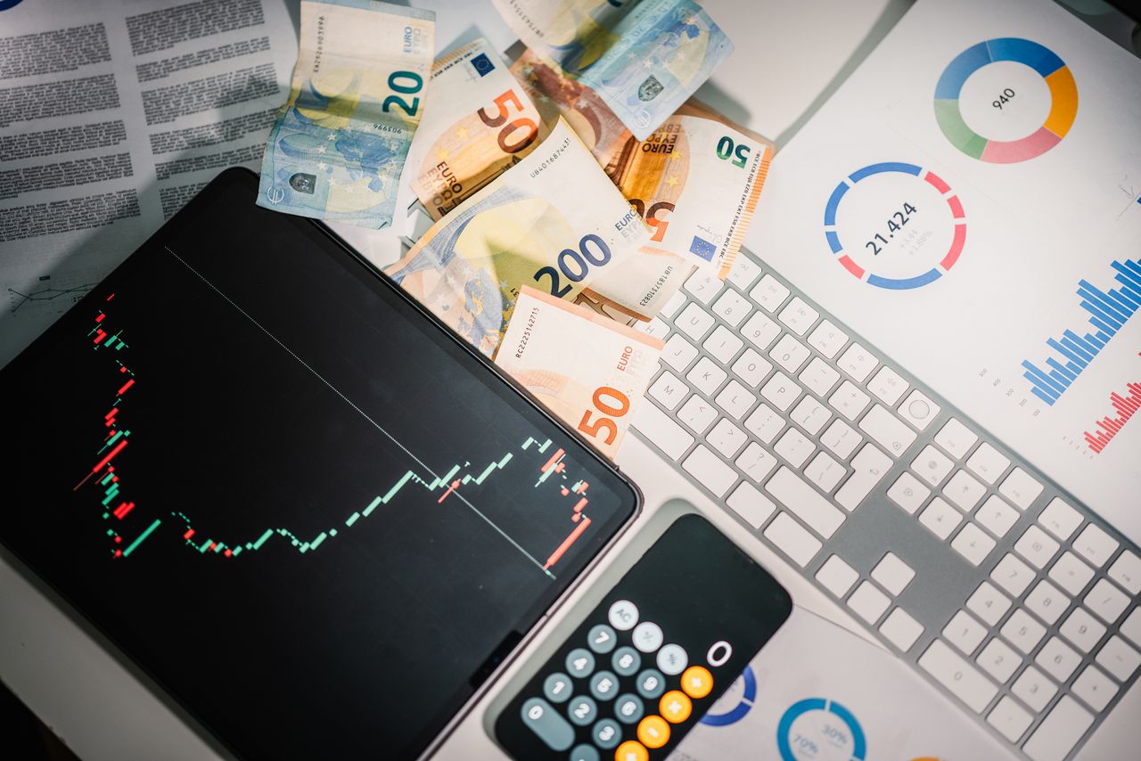 services-02 Overhead view of financial tools with Euro banknotes on a desk showing market trends and graphs.